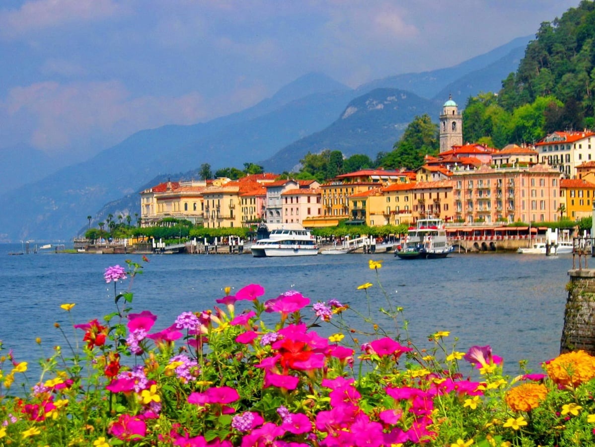 Bellagio sul Lago di Como, con fiori colorati in primo piano e montagne sullo sfondo