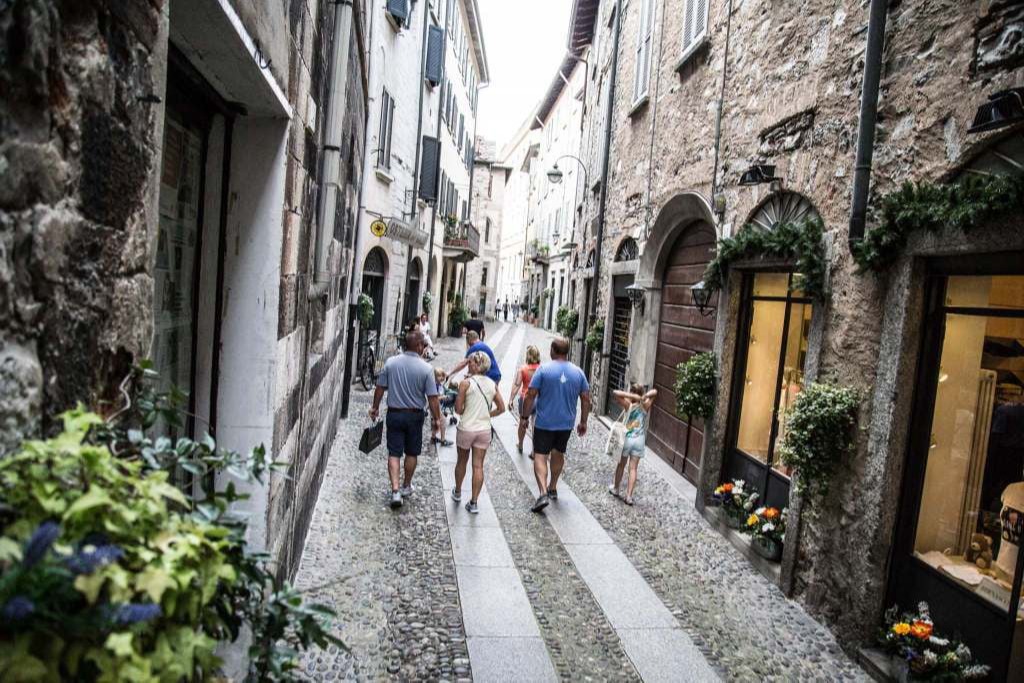 Via Vitani a Como, antica strada medievale con negozi, ristoranti storici e un'atmosfera suggestiva nel centro storico della città.